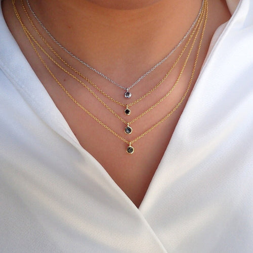 Necklace with small black stones on a white shirt